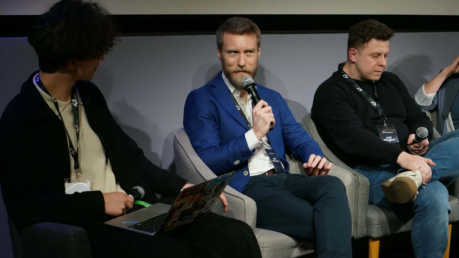 Panelists with microphones on stage during the hackathon panel